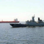 Pakistan Navy warship escorting commercial cargo ship in Arabian Sea to secure Pakistan trade routes during Strait of Hormuz crisis